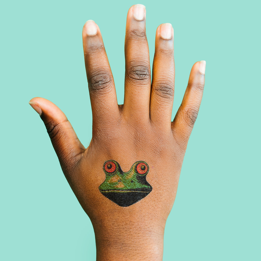 Trippy Frog Face Tattly Temporary Tattoo On A Person's Hand