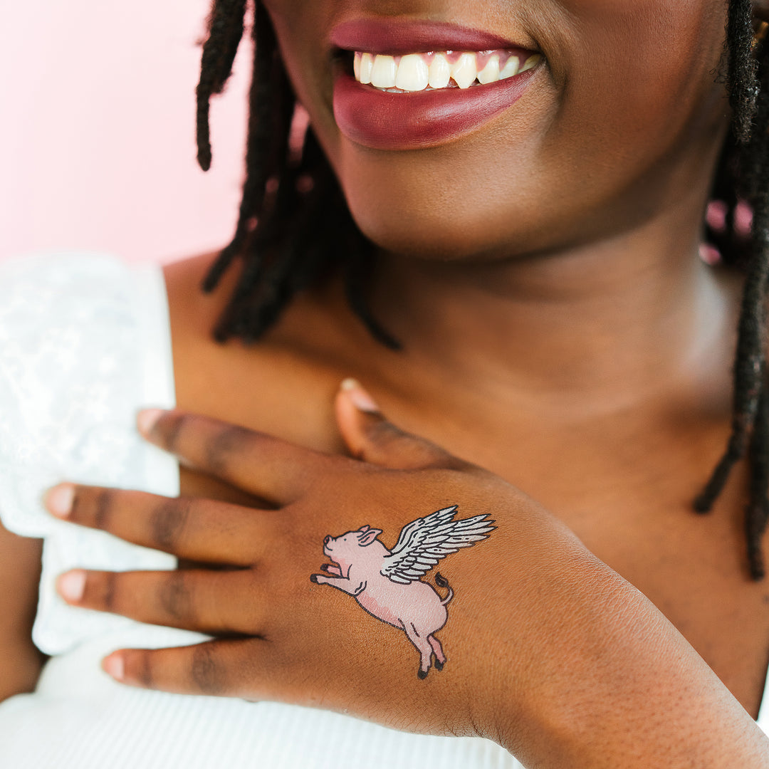 Flying Pig Tattly Temporary Tattoos On A Person's Hand