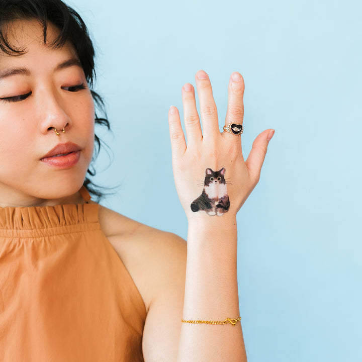 Curious Cat Tattly Temporary Tattoos On A Person's Hand